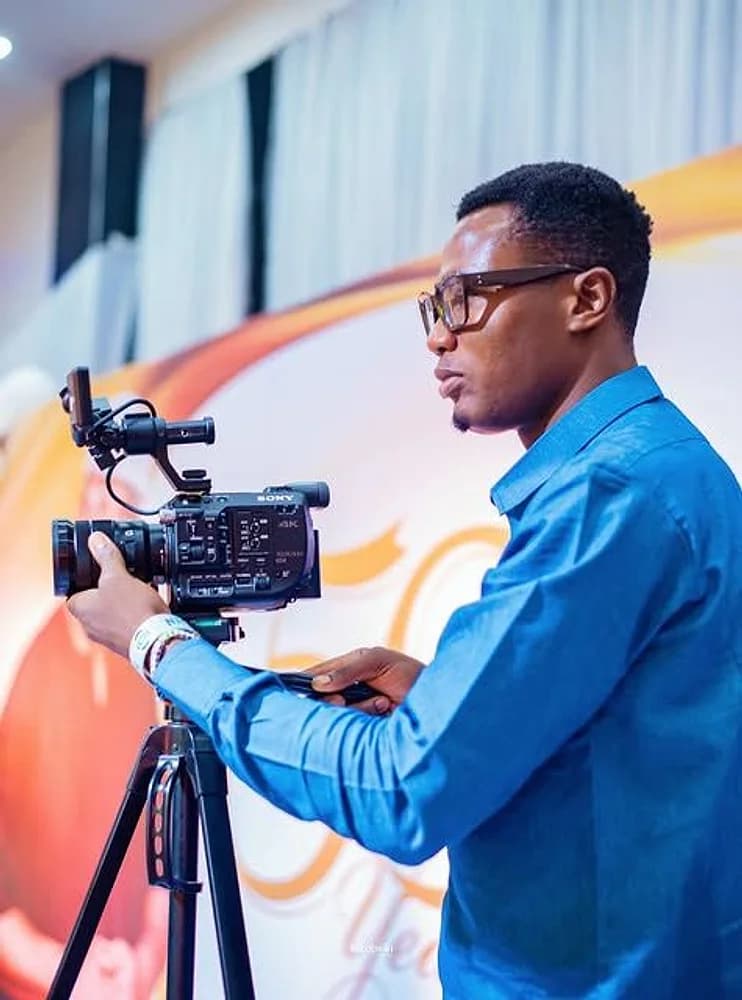Director Mide operating a cinema camera on a tripod